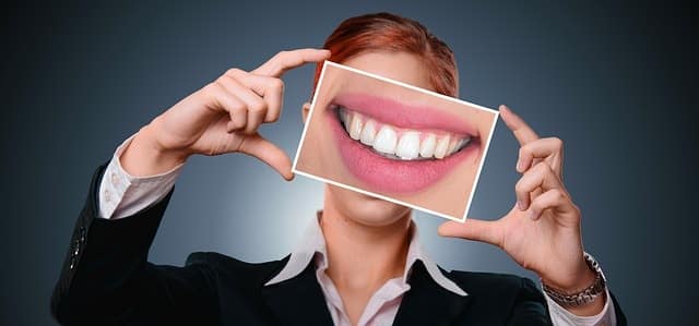 Invisalign review woman smiling after dental work has straightened teeth.